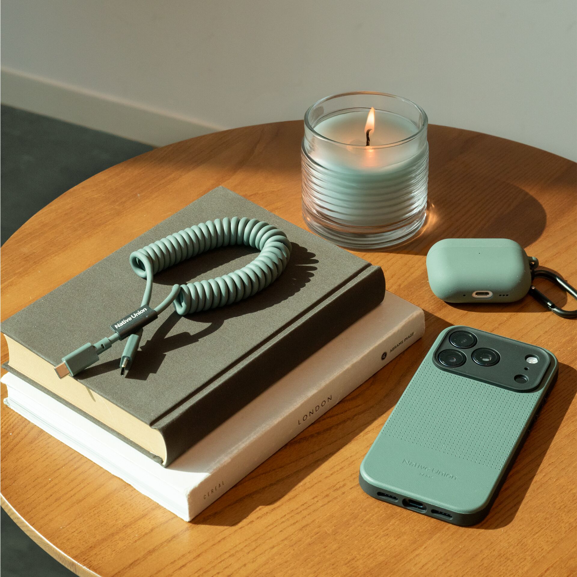 Smartphone case, Mint green, Textured, Wireless charging case, AirPods case?, Cable coil, USB-C adapter, Book and candle, Desk accessories