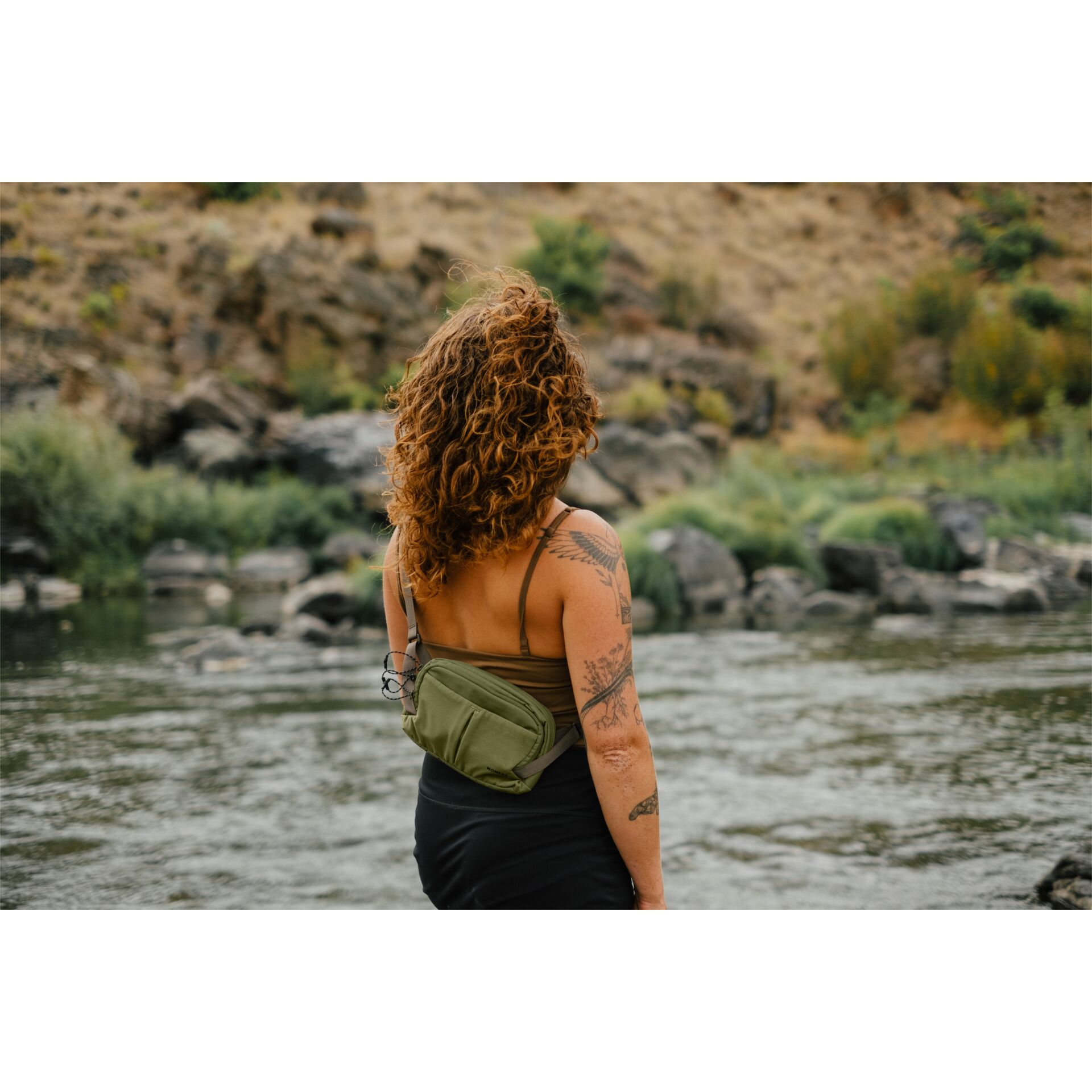 tote, arm tattoo, curly hair, olive bag, outdoor river