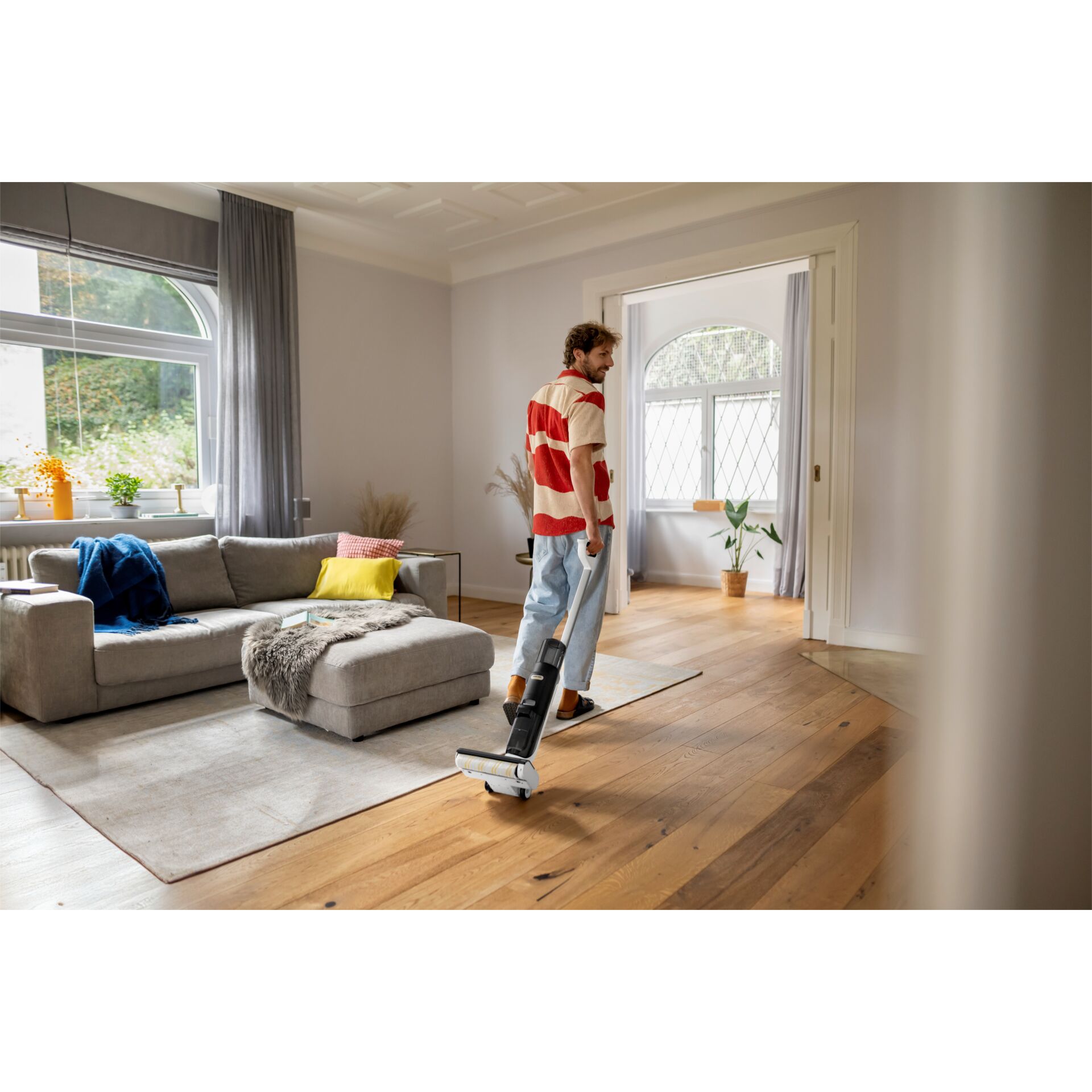 Staubsauger, Akku-Staubsauger, Wohnzimmer, Holzboden, Person mit Staubsauger